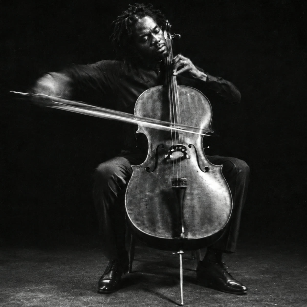 Cellist mid-stroke, bow blurred